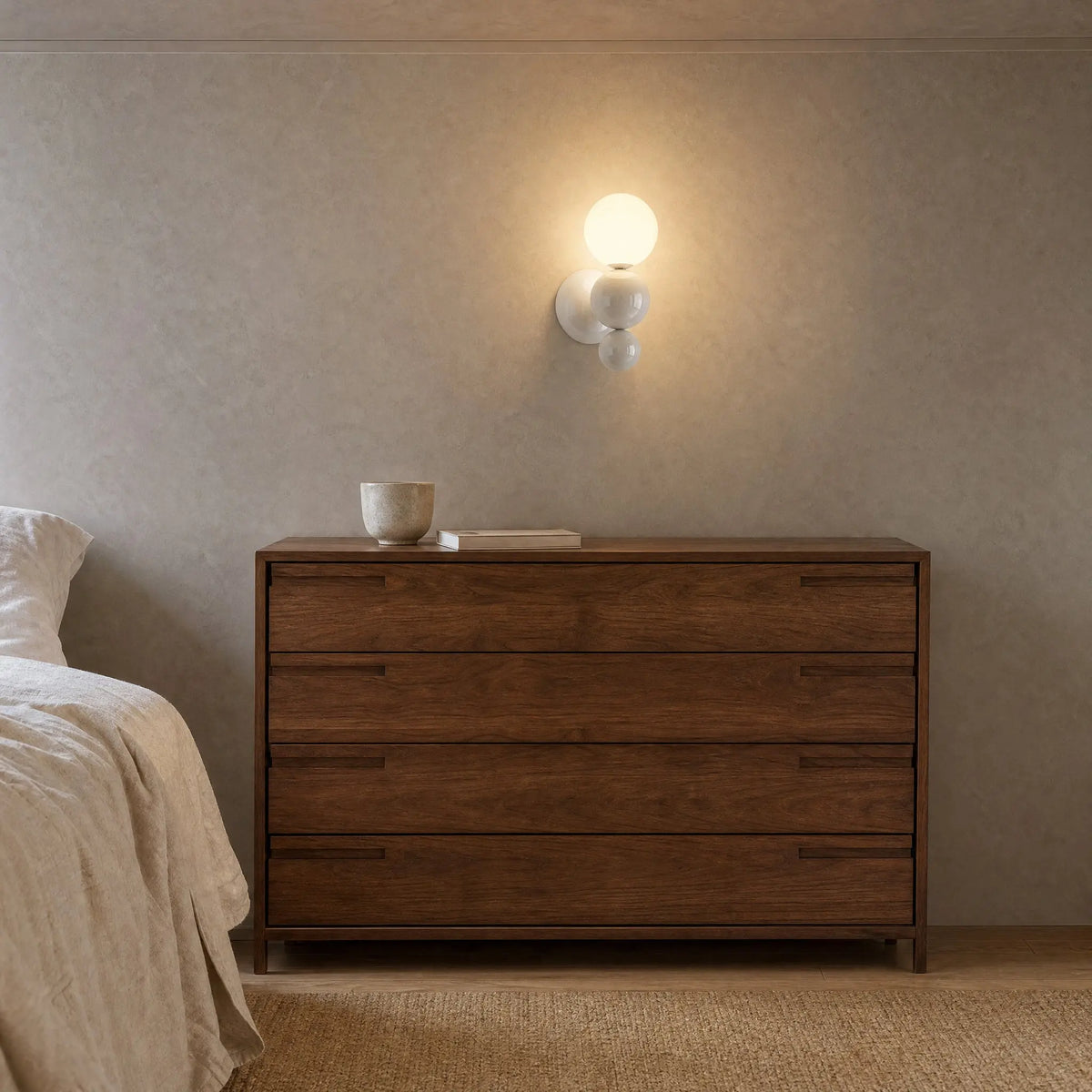Applique murale boule blanche allumée au-dessus d'une commode en noyer dans une chambre