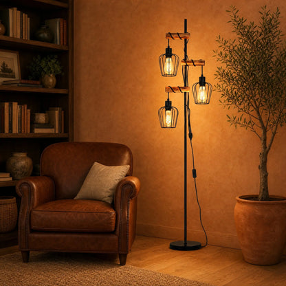 Lampadaire industriel 3 têtes allumé dans un salon au fauteuil cuir cognac | Delvanie