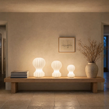 Trois lampes d'ambiance cocon allumees alignees sur un banc de chene | Delvanie