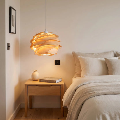 Suspension bois sculptée Rozenya éclairant une table de chevet dans une chambre