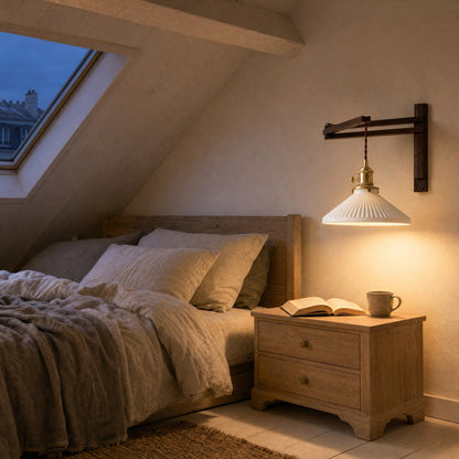 Applique murale allumée au-dessus d'une table de chevet dans une chambre sous combles | Delvanie