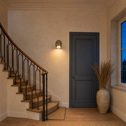 Applique murale originale allumée dans une montée d'escalier au crépuscule | Delvanie