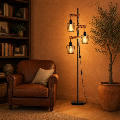Lampadaire industriel 3 têtes allumé dans un salon au fauteuil cuir cognac | Delvanie