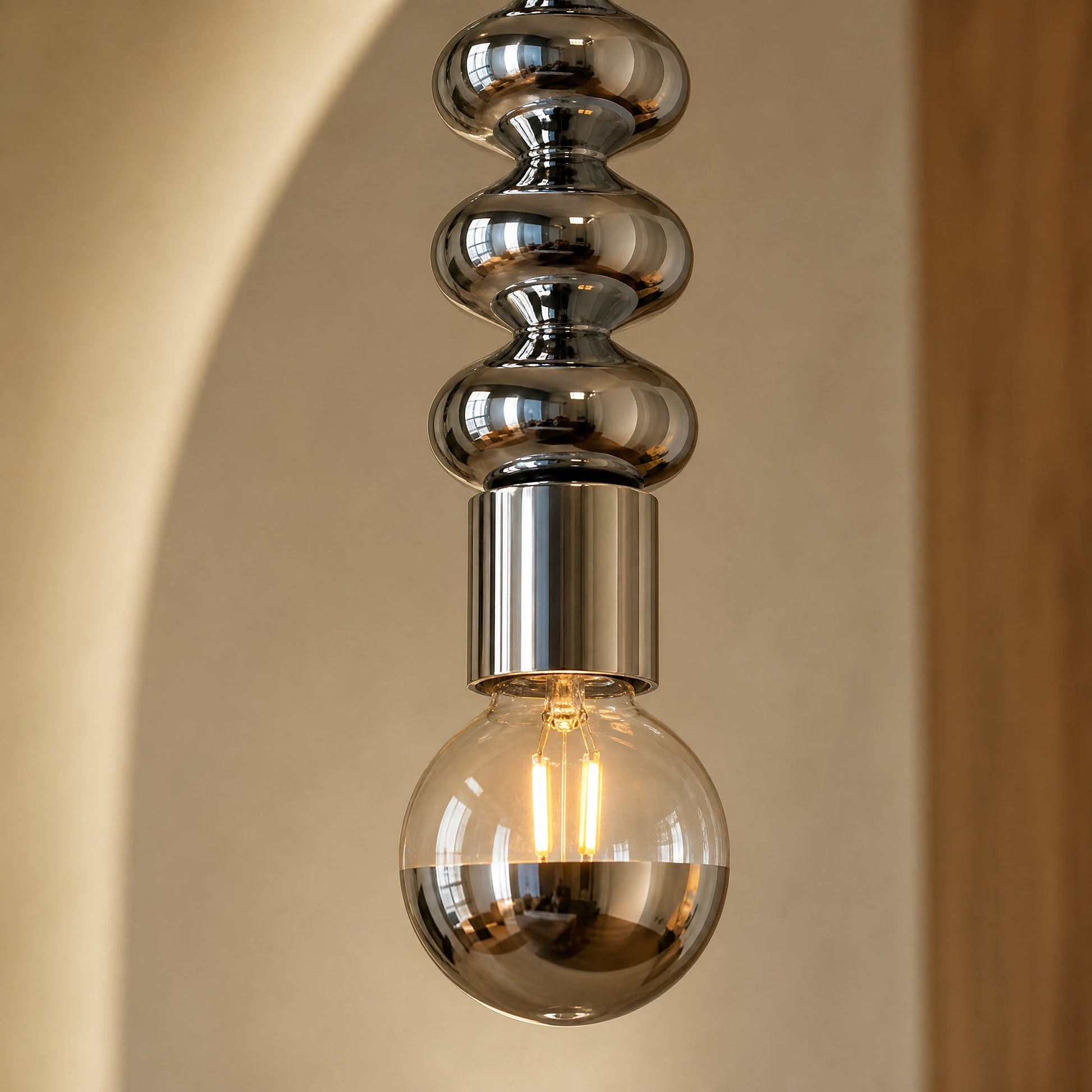 Détail des perles chromées et du globe demi-miroir allumé de la suspension Tamayu | Delvanie
